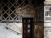 Alte Tür am Ende einer Treppe in einem alten Gebäude mit Jugendstil-Wand-Dekor, Rom, Italien