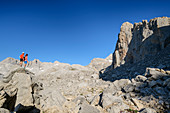 Man and woman while hiking stand on rocks and look at Horcados Rojos, Horcados Rojos, Picos de Europa, Picos de Europa National Park, Cantabrian Mountains, Cantabria, Spain