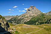 Woman hiking with Pic du Midi d'Ossau in the background, Pyrenees National Park, Pyrénées-Atlantiques, Pyrenees, France