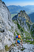 Frau beim Bergsteigen steigt über Klettersteig zur Pyramidenspitze auf, Pyramidenspitz-Klettersteig, Kaisergebirge, Tirol, Österreich