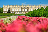 Park with flower borders, out of focus, and Herrenchiemsee Palace, Herrenchiemsee, Chiemsee, Upper Bavaria, Bavaria, Germany