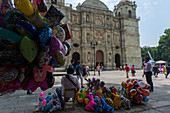 Menschen verkaufen Luftballons auf dem Platz vor der Kathedrale Unserer Lieben Frau von Mariä Himmelfahrt, erbaut in einem neoklassizistischen Stil, in der Stadt Oaxaca de Juarez, Oaxaca, Mexiko.