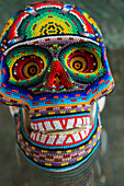 Ein mit Glasperlen bedeckter Schädel, ausgestellt in einer Kunstgalerie in Oaxaca City, Mexiko.