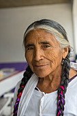 Porträt einer älteren mixtekischen Frau mit geflochtenem Haar im mixtekischen Dorf San Juan Contreras bei Oaxaca, Mexiko.