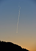 Airplane over a mountain at dusk with contrails, near Ybbs, Danube, Austria