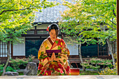 Kyoto, Japan Japanese woman kneeling in prayer. .