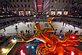 People ice skate at the famous lower plaza ice skating arena of Rockefeller Center during Christmas winter season in Manhattan New York City, USA.