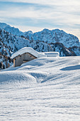 Landschaft der schneebedeckten Berghütten in der Ortschaft Ciamp de Lobia, Fedaia-Pass, Rocca Pietore, Marmolada, Dolomiten, Belluno, Venetien, Italien