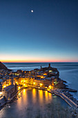Eine Mondnacht, die die Szene den ersten Lichtern des Sonnenaufgangs über dem malerischen Dorf Vernazza und seinem Hafen überlässt. Dieses Foto wurde von einem Aussichtspunkt entlang des Pfades der Liebe - Cinque Terre National ParK, Ligurien, Italien Europa aufgenommen