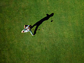 Mann, der Golf auf Golfplatz spielt