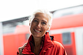 Portrait of smiling woman with long white hair, looking at camera.