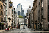 Blick entlang der leeren Fleet Street mit Bürogebäuden und der St. Paul's Cathedral zwischen modernen Hochhäusern in London während der Corona-Virus-Krise