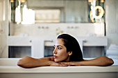 Woman relaxing in bathtub in suite