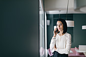 Young businesswoman in hotel making smartphone call