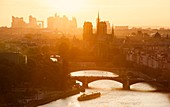 Frankreich, Paris, Gebiet, das von der UNESCO zum Weltkulturerbe erklärt wurde, die Ufer der Seine, die Kathedrale Notre Dame und das Viertel La Defense im Hintergrund bei Sonnenuntergang