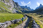 France, Savoy, Pralognan La Vanoise, Vanoise National Park, GR55, Vanoise Pass trail (salt and Beaufort road), view of Pointe de la Grande Gliere (3392m) and Pointe de la Petite Gliere (3322m), woman practicing hiking