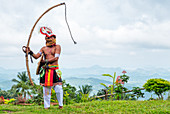 Caci man performing a traditional whip dance with bamboo shield and leather whip, western Flores, Indonesia, Southeast Asia, Asia