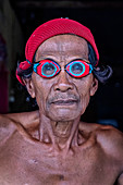 Porträt eines Bajau-Fischers, der gefertigte hölzerne Schutzbrille vom Mangrovenholz, Togian Island, Indonesien, Südostasien, Asien trägt