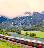 The Rauma Line express train runs beside the river in Romsdalen Valley, Andalsnes, More og Romsdal county, Norway, Scandinavia, Europe