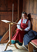 Young woman in traditional costume in the Ringebu Stave Church, Stavkyrkje Ringebu, Ringebu, Gudbrandsdalen, Rondanevegen, Oppland, Norway, Europe