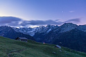 Stars over tent and huts overlooking Piz Badile and Piz Cengalo, Tombal, Soglio, Valbregaglia, Canton of Graubunden, Switzerland, Europe