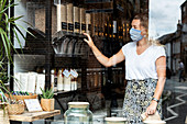 Woman wearing face mask shopping in waste-free local store, sustainability.