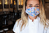 Frau mit Gesichtsmaske beim Einkaufen in einem abfallfreien lokalen Geschäft, Nachhaltigkeit