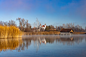 Bliock over the Kochelee to Schlehdorf with the Schlehdorf Monastery and fishermen's huts on the shore, Bavaria, Germany.