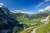 Woman hiking climbs up to Glecksteinhütte, Eiger, Kleine Scheidegg and valley floor of Grindelwald in the background, Glecksteinhütte, Bernese Oberland, UNESCO World Heritage Site Swiss Alps Jungfrau-Aletsch, Bernese Alps, Bern, Switzerland