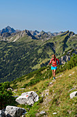 Woman hiking up to Litnisschrofen, Hochvogel in the background, Litnisschrofen, Tannheimer Berge, Tyrol, Austria