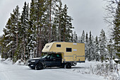 Wohnmobil im tiefen Schnee im Wald in Lappland, Suddesjaur, Schweden