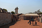 Gambia; Central River Region; Straße in Janjanbureh; früher Georgetown; Mann und Junge fahren auf einem Eselskarren