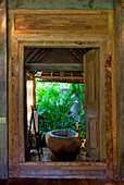 Steinbadewanne in einem offenen Badezimmer in einem alten Holzhaus im Dschungel. Bali, Indonesien.
