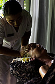 Gesichtsmassage an Frau von balinesischen Therapeuten durchgeführt. Bali, Indonesien.