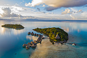 Luftaufnahme des Sofitel Bora Bora Private Island Resort mit Überwasserbungalows in der Lagune von Bora Bora bei Sonnenaufgang, Vaitape, Bora Bora, Leeward Islands, Französisch-Polynesien, Südpazifik