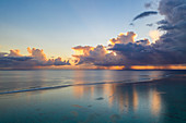 Luftaufnahme vom Wolkenhimmel zum Sonnenuntergang mit Regenschauern entlang der Lagune von Moorea, Avamotu, Moorea, Windward Islands, Französisch-Polynesien, Südpazifik