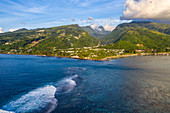 Luftaufnahme von Surfern auf Wellen am Riff, das die Lagune vom Südpazifik trennt mit Bergen dahinter, nahe Papeete, Tahiti, Windward Islands, Französisch-Polynesien, Südpazifik