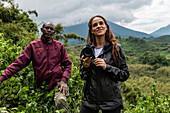 Ranger Guide und junge Frau während eines Trekking Ausflug zur Sabyinyo Gruppe von Gorillas, Volcanoes National Park, Northern Province, Ruanda, Afrika