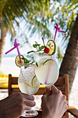 Hands holding two cocktail glasses with fresh lime juice in the restaurant and bar of the Ancarine Beach Resort on Ong Lang Beach, Ong Lang, Phu Quoc Island, Kien Giang, Vietnam, Asia
