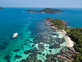 Aerial view of John's Tours No. 9 excursion boat and tourists snorkeling in clear water near beach with coconut palms, Dam Ngang Island, near Phu Quoc Island, Kien Giang, Vietnam, Asia