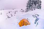 Blick auf orangefarbenes Zelt in einer winterlichen Landschaft
