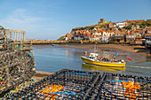 View of St. Mary's Church and restaurants, houses and boats on the River Esk, Whitby, Yorkshire, England, United Kingdom, Europe
