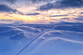 Arktischer Sonnenuntergang über Tanafjordveien leere Straße, die die schneebedeckten Berge nach Schneesturm, Tana, Troms og Finnmark, Arktis, Norwegen, Skandinavien, Europa kreuzt