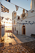 Sonnenuntergang in Plaka, dem Hauptort auf Milos, mit griechisch-orthodoxer Festdekoration auf dem Kirchenplatz mit Kieselmosaik, Plaka, Milos, Kykladen, griechischen Inseln, Griechenland, Europa