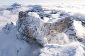 Monte Pelmo surrounded by a sea of clouds in winter, aerial view, Dolomites, Belluno province, Veneto, Italy