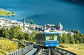 Funicular car uphill with St. Moritz lake and village in the background, Engadine, canton of Graubunden, Switzerland