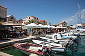 Fischerboote im Hafen und Menschen in Restaurants in der Altstadt, Primosten, Šibenik-Knin, Kroatien, Europa