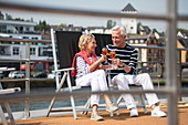 Couple enjoying cocktails on the sundeck of the river cruise ship during a cruise on the Rhine, near Andernach, Rhineland-Palatinate, Germany, Europe