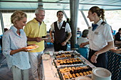Paar an der Kuchenstation während der Kaffeezeit am Nachmittag in der Panorama Lounge an Bord von Flusskreuzfahrtschiff während einer Kreuzfahrt auf dem Rhein, Goarshausen Wellmich, Rheinland-Pfalz, Deutschland, Europa