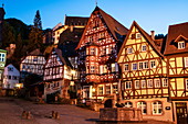 Fountain and half-timbered houses at the historic Schnatterloch market square with Mildenburg Castle at dusk, Miltenberg, Spessart-Mainland, Franconia, Bavaria, Germany, Europe